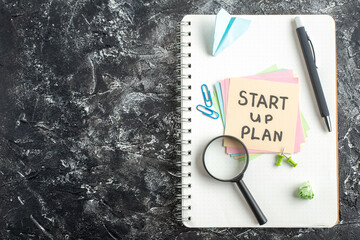 Wall Mural - top view start up plan note on sticker with pen and magnifier on a gray background lesson student no