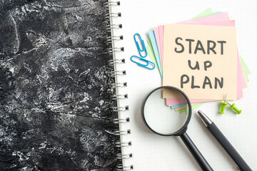 Wall Mural - top view start up plan note on sticker with pen and magnifier on gray background lesson student note