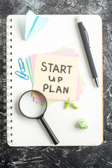 Wall Mural - top view start up plan note on sticker with pen and magnifier on gray background lesson student note