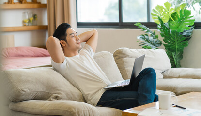 Wall Mural - portrait of asian man sitting on sofa at home