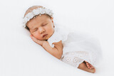 Fototapeta  - Newborn baby girl portrait, photographed in studio. Dressed in white dress.