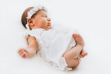 Fototapeta  - Newborn baby girl portrait, photographed in studio. Dressed in white dress.