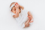 Fototapeta  - Newborn baby girl portrait, photographed in studio. Dressed in white dress.