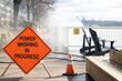 Power washing of walkway by workers, walkway closed and road closing sign established