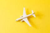 Fototapeta Boho - Travel style of flat lay design featuring white plane on vibrant yellow background. Generative AI