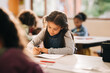© Jacob Lund - Kid writes on a book in a primary school class