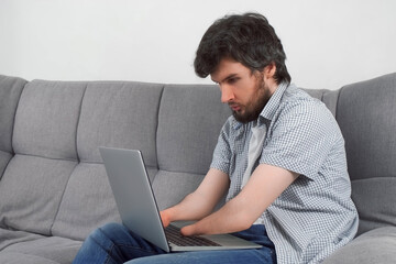 Wall Mural - Handicapped disabled man with amputated two stump hands working typing on laptop at home looking at camera. Problem adaptation to life people with disabilities. Independent Invalid person.