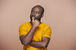 © pressmaster - Portrait of African American man contemplating about something standing against brown background