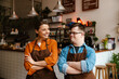 © Drobot Dean - Man with down syndrome and his female colleague smiling while standing in cafe with arms folded