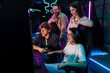 © Drobot Dean - Group of people watching their friend playing video game in cybersport club