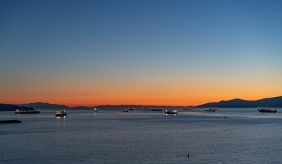 Sticker - a harbor full of boats at sunset as the sun sets