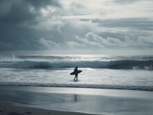 A Lone Surfer Braving The Waves On A Remote Beach