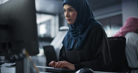 Poster - Thoughtful Middle Eastern Engineer Working on Computer in a Technological Corporate Office. Young Muslim Woman Writing Software Code for an Innovative Internet and Software as a Service Project