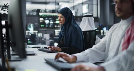 Poster - Diverse Young Arab Colleagues Working on Computers in a Research Laboratory. Focus on Middle Eastern Female Software Developer Working on a Solution for Their Collaborative Industrial Tech Project