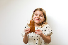 Happy Girl Holding Bunny Shape Gingerbread Against White Background