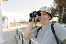 Happy Man Sticking Out Tongue And Looking Through Binoculars