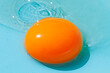 © ADDICTIVE STOCK - Orange egg yolk on blue background