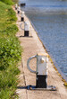 A line of mooring posts on river bank recede into the distance with front one in focus and rest deliberately blurred