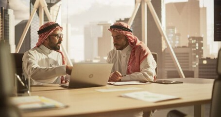 Poster - Arab Financial Analyst Having a Meeting to Discuss a Project with a Team Leader. Middle Eastern Colleagues Using Laptop Computer, Working in Modern Office, Wearing Traditional Thobe and Kaffiyeh