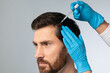 Mesotherapy for male hair. Handsome man receiving injections in his head, having mesotherapy session at beauty salon