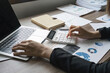 © Natee Meepian - Bookkeeper using a calculator to calculate numbers on a company's financial documents, he is analyzing historical financial data to plan how to grow the company. Financial concept
