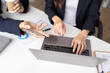 © Tj - Happy young Asian businessman and woman shaking hands to congratulate successful collaboration on business deal with documents and laptop on table in the office.