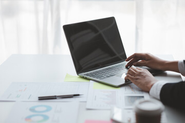 A business women working in a private room, He is typing on a laptop keyboard, He uses a messenger to chat with a partner. Concept of using technology in communication.