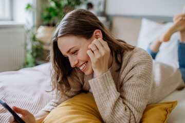 young woman scrolling her smartphone in the apartment.