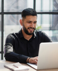 Bearded young businessman working on modern office. Consultant man thinking looking in monitor computer