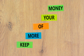 Keep more of your money symbol. Concept words Keep more of your money on colored paper. Beautiful wooden table wooden background. Business keep more of your money concept. Copy space.