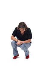 Wall Mural -  front view of a young girl crouching and searching at the ground on white background