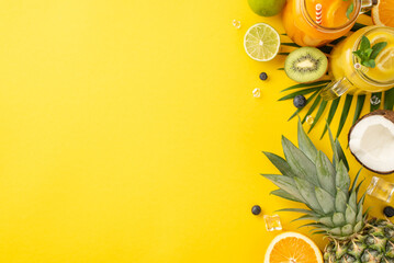 Add a pop of color to your summer marketing with this vibrant top view flat lay photo of citrus juice cocktails in glass jars, ananas, orange, kiwi set against a trendy yellow background