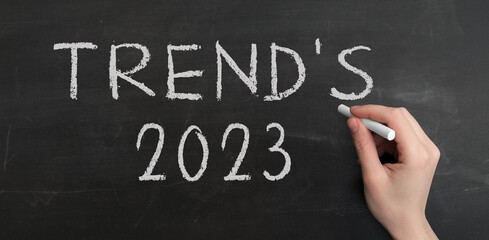 Poster - a woman's hand write text trend's 2023 with chalk on chalkboard