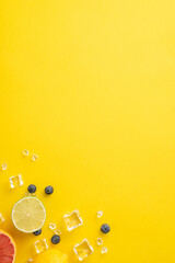 Wall Mural - Fresh citrus concept. Top vertical view of juicy orange, lemon, lime and grapefruit on yellow background with empty space for text