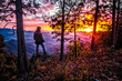 man watching red sunset in amazing landscape with mountains in the background and forest in foreground, sierra madre occidental in durango mexico 