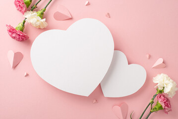 Wall Mural - A stunning Mother's Day gift arrangement. Top view photo of pink carnations, and paper hearts arranged on a pastel pink background with two empty hearts for text or branding