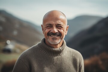 Wall Mural - Portrait of a smiling senior man in the mountains. He is looking at camera and smiling.