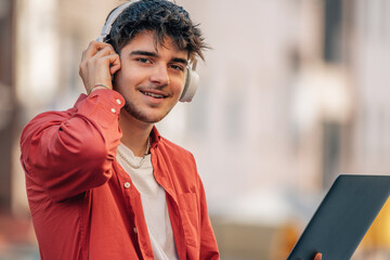 Poster - young male with headphones and laptop in the street