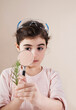 © Designpics - Portrait of Young Girl Wearing Goggles on Head and Looking through Magnifying Glass at Plant, Studio Shot