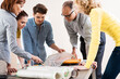 © Designpics - Business People in Meeting Looking at Plans and Model of Windmill