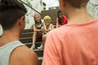 © Designpics - Backview of two boys talking to girls sitting on stairs outdoors, Germany