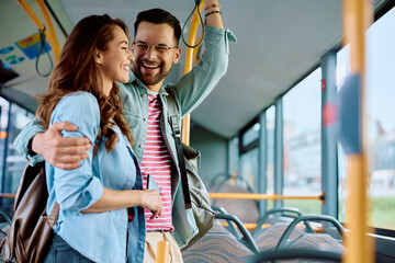 Wall Mural - Cheerful couple having fun while riding in bus.