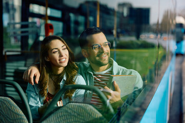 Wall Mural - Happy man and is girlfriend traveling by city bus and looking through window.