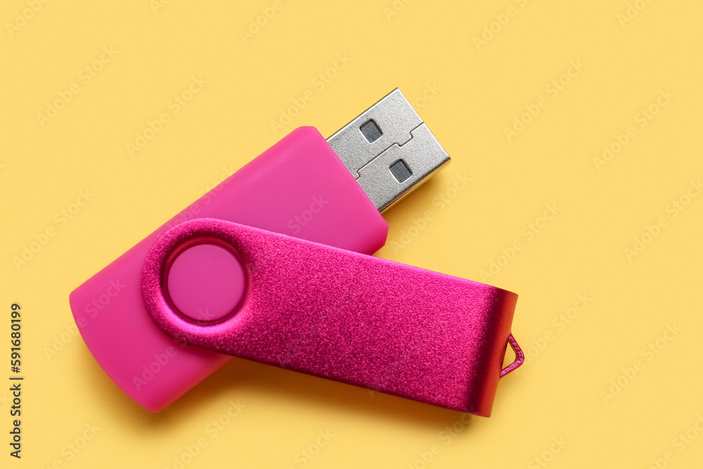 Pink USB flash drive on yellow background