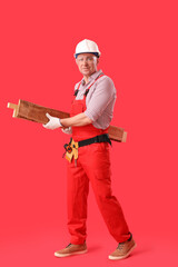 Canvas Print - Mature carpenter with wooden planks on red background