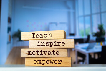 Wooden blocks with words 'Teach inspire motivate empower'.