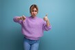 distressed upset blond young woman in purple hoodie showing like and dislike on blue background with copy space