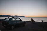 Fototapeta  - anziano sulla spiaggia al tramonto con macchina