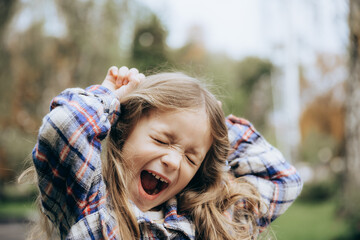 portrait of a happy and smiling little girl posing for a photo during a summer walk in the city