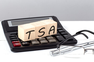 Wall Mural - TSA concept on wooden cubes on calculator on white background